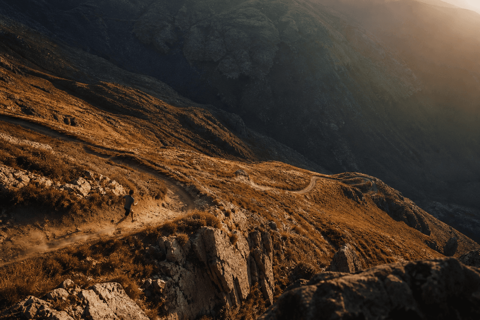 Trail runner on a mountain ridge at golden hour